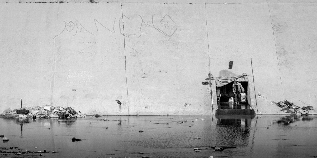 Homeless person living inside a Tijuana River Channel outlet drain.